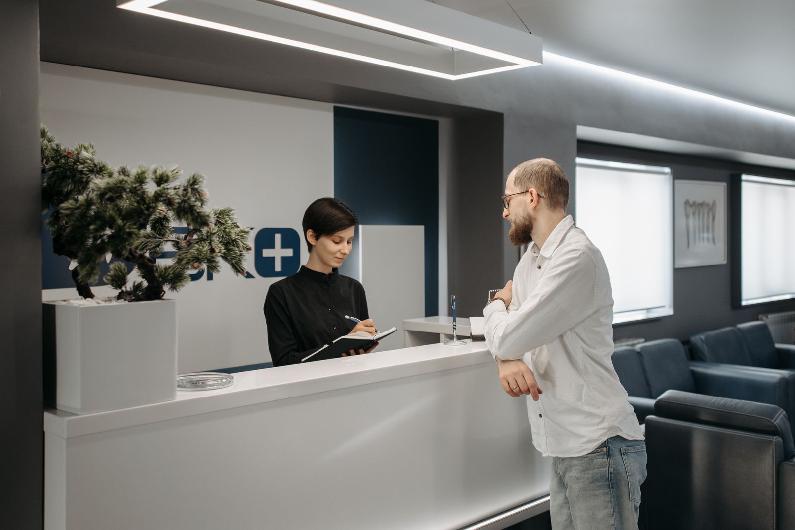 Patient speaking with a receptionist in a dental clinic